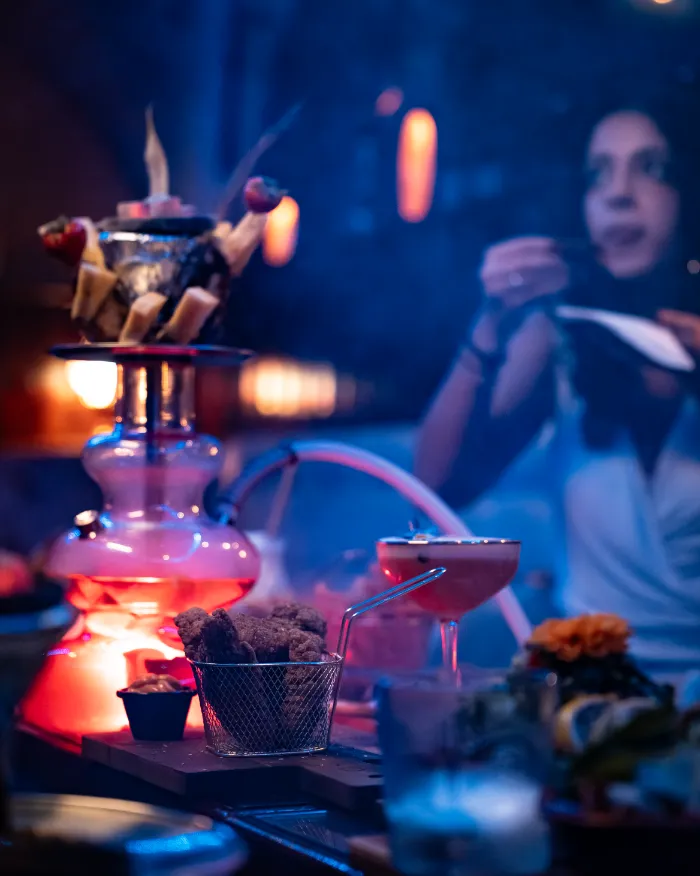 Table with shisha flavorful dishes and mocktails creating a relaxed evening setting at private lounge